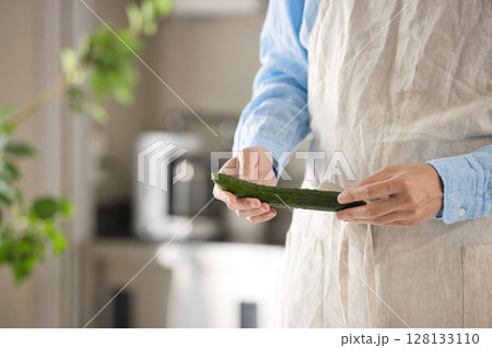 野菜を切る若い男性の手元 128133110