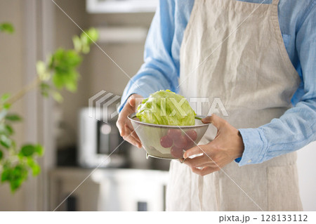 野菜を切る若い男性の手元 128133112
