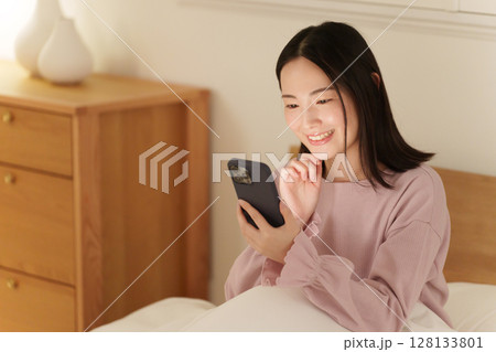 夜中にスマホを見る女性 128133801