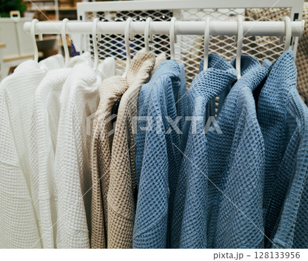Rack of clothes with a blue and white striped shirt hanging from it Rack of clothes with a blue and white striped shirt hanging from it 128133956