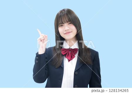 塾や予備校などの大学受験イメージ女子高生 指差しポイント水色背景 スマホを持つ 塾や予備校などの大学受験イメージ女子高生 指差しポイント水色背景 スマホを持つ 128134265