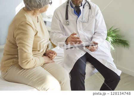 Close-Up Of Doctor Talking To Elderly Patient 128134748
