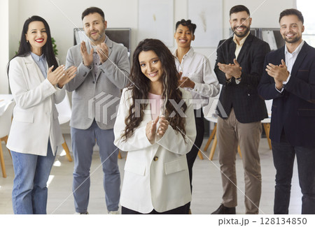 Happy diverse group of colleagues clapping, celebrating achievement, woman leader applauses Happy diverse group of colleagues clapping, celebrating achievement, woman leader applauses 128134850
