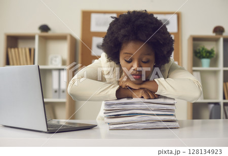 African american woman office worker sleeping on paper document stack at desk 128134923