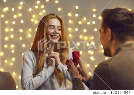 Excited young woman getting and accepting a marriage proposal from her boyfriend Excited young woman getting and accepting a marriage proposal from her boyfriend 128134947