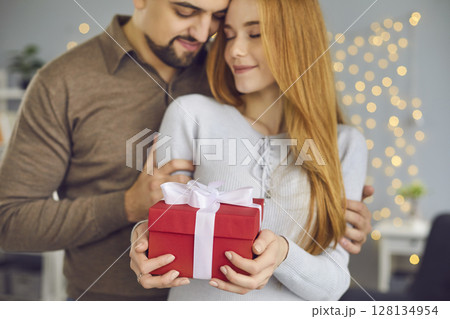 Happy young couple celebrating their special day and enjoying romantic presents 128134954