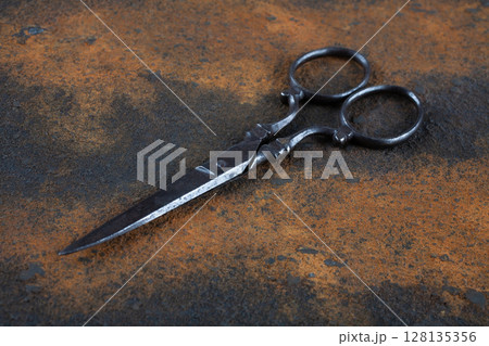Vintage embroidery scissors on rusty background 128135356