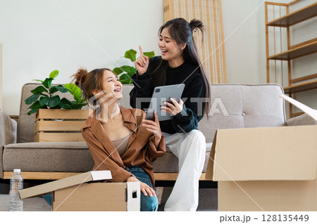 Happy Lesbian Couple Moving into Smart Home, Unpacking Boxes and Using Tablet to Set Up Modern Technology in New House Happy Lesbian Couple Moving into Smart Home, Unpacking Boxes and Using Tablet to Set Up Modern Technology in New House 128135449