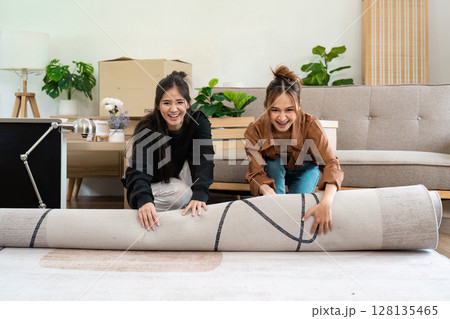 Happy Lesbian Couple Moving into New Home, Unrolling Carpet in Living Room, LGBT Family Starting New Life Together Happy Lesbian Couple Moving into New Home, Unrolling Carpet in Living Room, LGBT Family Starting New Life Together 128135465