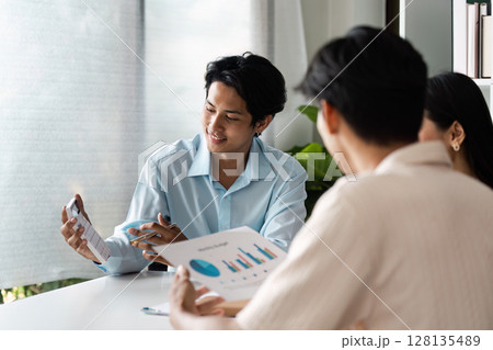 Young Couple Discussing Financial Plan Investment with Professional Advisor in Modern Office Setting 128135489