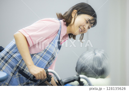車椅子を押す介護士 128135626