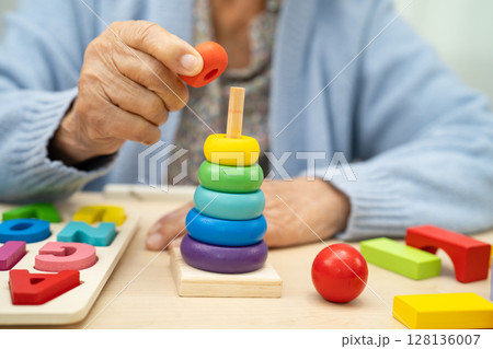 Alzheimer disease AD, Asian elderly woman patient suffering from dementia learn practical motor skills rehabilitation. 128136007