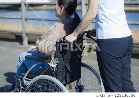車椅子に乗る女性性と介護士  128136350