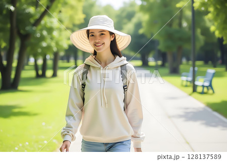 夏の公園を歩く つばの広い帽子を被った女性 夏の公園を歩く つばの広い帽子を被った女性 128137589