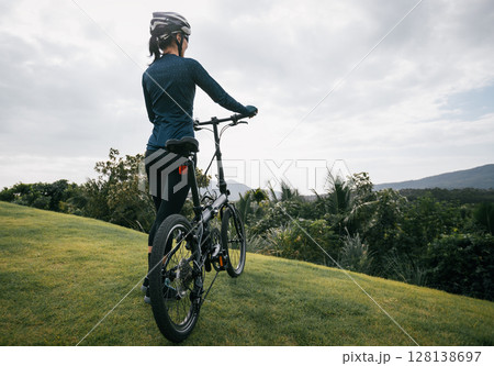 Riding folding bike to tropical mountain peak Riding folding bike to tropical mountain peak 128138697