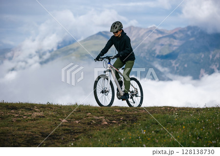 Asian woman riding mountain bike on beautiful mountain top 128138730