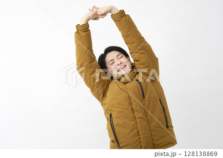 ダウンジャケットを着た男性　伸び　白背景 128138869