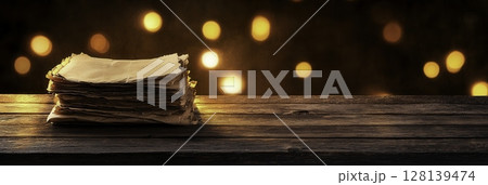 Stacked Vintage Paper on Wooden Table Against Soft Glowing Background Stacked Vintage Paper on Wooden Table Against Soft Glowing Background 128139474