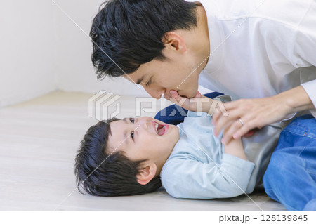 お家のリビングで息子と遊ぶお父さん お家のリビングで息子と遊ぶお父さん 128139845