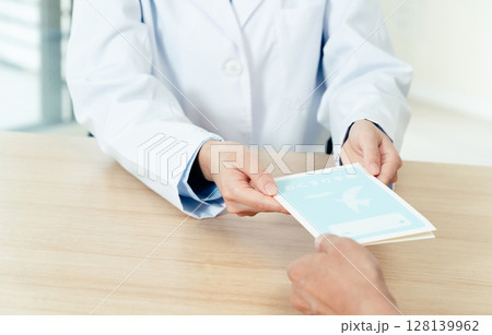 お薬手帳を渡す薬剤師の女性 128139962