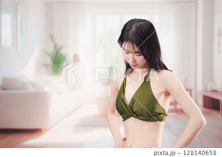 家で水着を試着して体型を気にする若い女性 128140658