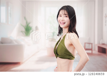 家で水着を試着して体型を気にする若い女性 128140659