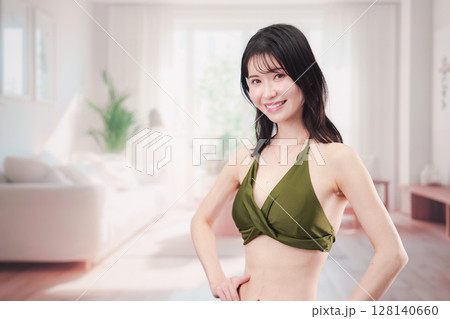 家で水着を試着して体型を気にする若い女性 128140660