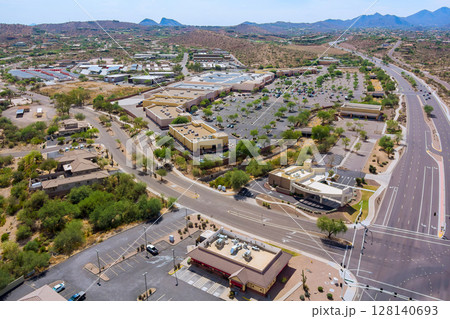 Shopping center commercial district in Fountain Hills, Arizona business area features multiple buildings, parking lots, office buildings along East Shea Boulevard in this suburban commercial zone. 128140693