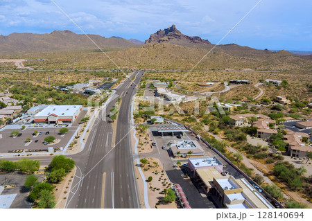 East Shea Boulevard running through Fountain Hills, Arizona multi lane highway divides commercial residential areas desert landscape mountains rise in Maricopa County. 128140694