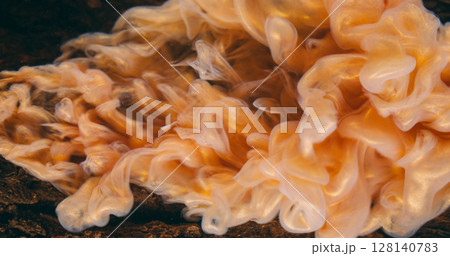 Swirling mist. Ink fluid. Defocused golden brown color glow water texture smog acrylic flowing on abstract wooden bark background. Swirling mist. Ink fluid. Defocused golden brown color glow water texture smog acrylic flowing on abstract wooden bark background. 128140783