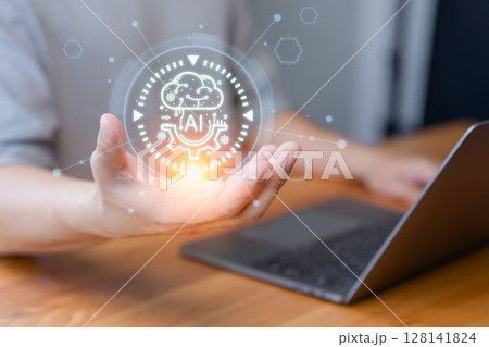 Person hand presenting a glowing AI symbol with a laptop in the background. Represents artificial intelligence, innovation, and futuristic technology concept. Person hand presenting a glowing AI symbol with a laptop in the background. Represents artificial intelligence, innovation, and futuristic technology concept. 128141824