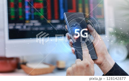 Hand holding smartphone with 5G icon and global network interface, representing high-speed wireless technology, digital connectivity, IoT, and future communication concept. communication network. Hand holding smartphone with 5G icon and global network interface, representing high-speed wireless technology, digital connectivity, IoT, and future communication concept. communication network. 128142877