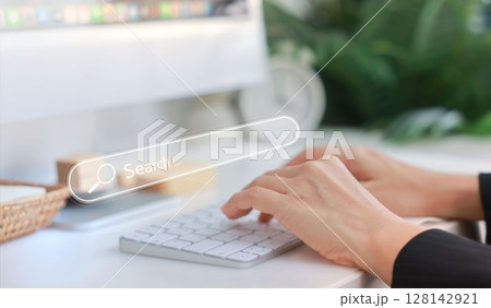 Hands typing on a white keyboard with search bar overlay, representing internet browsing, SEO, online research, digital marketing, communication, data input, coding and information search concept. Hands typing on a white keyboard with search bar overlay, representing internet browsing, SEO, online research, digital marketing, communication, data input, coding and information search concept. 128142921
