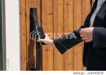 ドアの施錠をする女性の手元 128143679