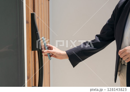 ドアの施錠をするスーツの女性 ドアの施錠をするスーツの女性 128143823