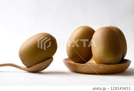 Fresh kiwi fruit with wooden plate and spoon on white background, Healthy eating Fresh kiwi fruit with wooden plate and spoon on white background, Healthy eating 128145631