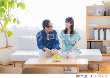 ソファーに座り談笑するミドル夫婦 128145723