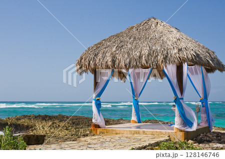 Gazebo by the sea, surrounded by beautiful turquoise waters, decorated for a wedding ceremony 128146746