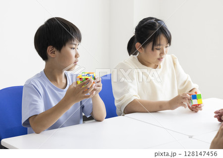 ルービックキューブをする小学生 128147456