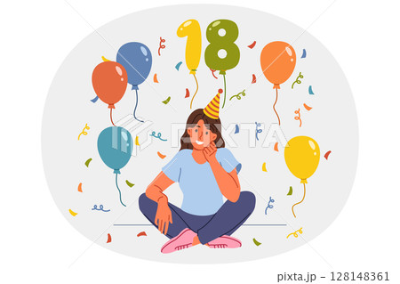 Woman celebrates 18th birthday, proud reaching adulthood, and sits on floor among candy and balloons Woman celebrates 18th birthday, proud reaching adulthood, and sits on floor among candy and balloons 128148361