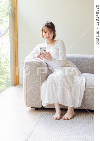 リビングでスマートフォンを使う女性 128148520