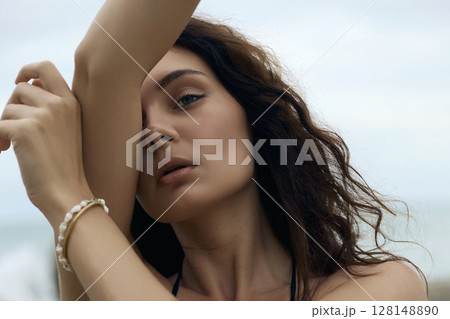 Beautiful brown hair young woman on beach. close-up portrait Beautiful brown hair young woman on beach. close-up portrait 128148890