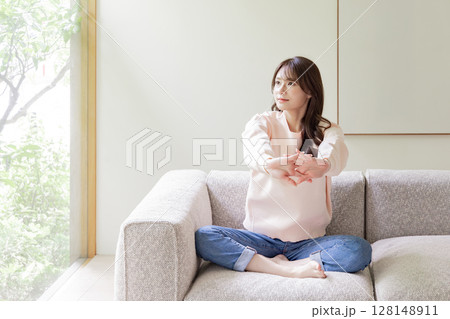 ソファでストレッチをする女性 128148911
