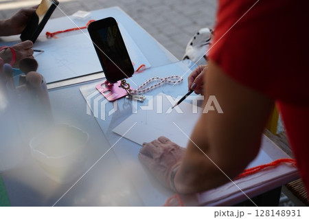 Artist Drawing at Outdoor Table with Smartphone References 128148931