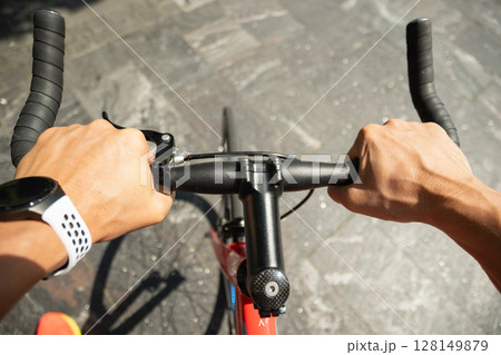 Cyclist or caucasian man hands on black bicycle handlebars. Close up 128149879