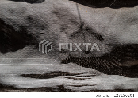 Close-up view of textured dark fabric showing weave pattern and folds. 128150201