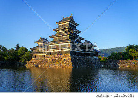 Matsumoto Castle reflecting in the water at sunset, Japan Matsumoto Castle reflecting in the water at sunset, Japan 128150585