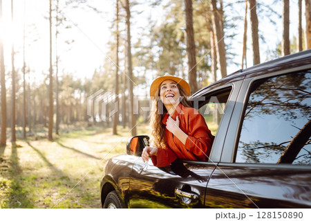 Young woman leaning out of the car window enjoying nature. Road trips summer holidays. Young woman leaning out of the car window enjoying nature. Road trips summer holidays. 128150890