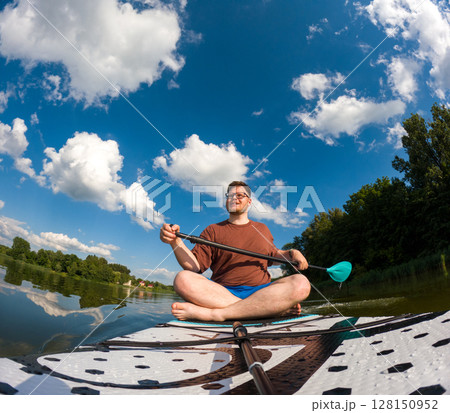 Man Taking Selfie on Paddleboard in Scenic Lake 128150952