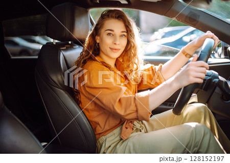 Stylish woman driving car. Traveler is the driver. Automobile travel. Sharing car. Lifestyle concept 128152197